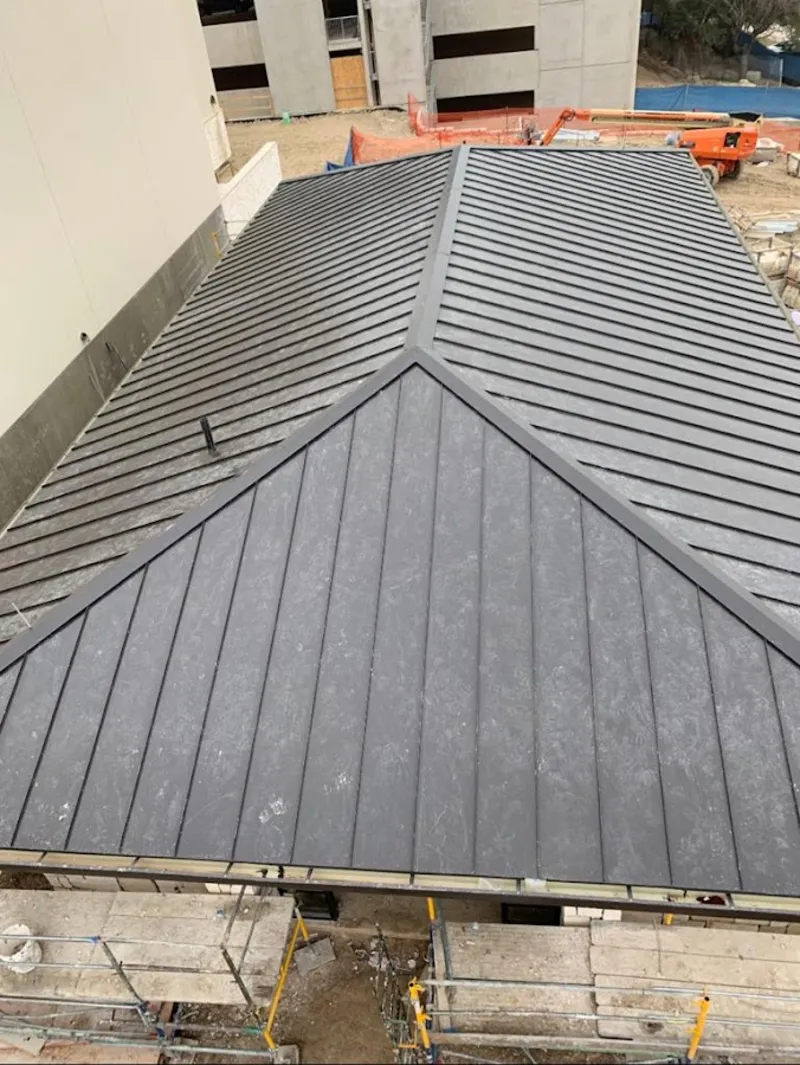 Commercial metal roof construction with crane equipment in Tallmadge